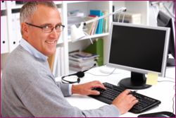 Closeup portrait of a happy senior man working on a computer