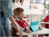 Happy,Schoolboy,Using,Digital,Tablet,During,Lesson,In,Classroom,At